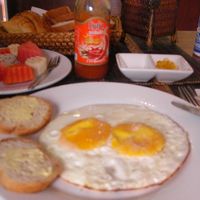 目玉焼きとフルーツ、ジュース、パンはクロワッサンとバゲット