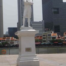 白いラッフルズさんはシンガポール川を背にしています。