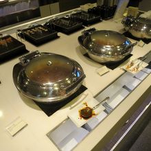 メインのビュッフェ台にはホットミール３種、奥には稲荷寿司やお