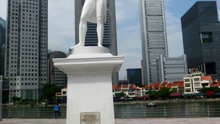 シンガポール川と高層ビルを背景に白のラッフル像が立つ