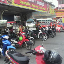 バイクタクシー待機場所の向こうに、客待ちのソンテウが見えます