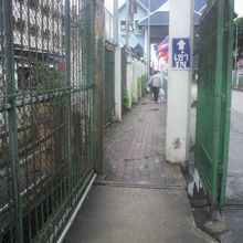 碑は、タイのイミグレ手前の白色の門の金網の横にあります。