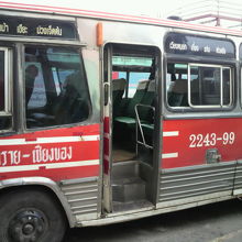 チェンライからチェンコンに向かう赤色車体のバスの側面です。