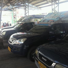 到着した高速バスの乗客を待つ一群のソンテウの様子です。