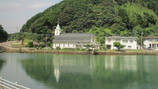 中ノ浦の入り江に水鐘の姿を映して静かに建っている尖塔のある教会です。