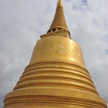 空にそびえる黄金色の仏塔です。