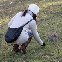 リスの餌付けを楽しむ女性