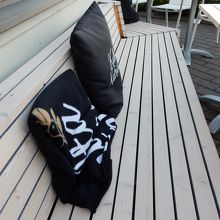 屋外の座席に置かれたクッションと肌掛け
