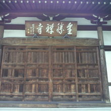 全勝寺の正面の木製の扉とその上の額の様子です。