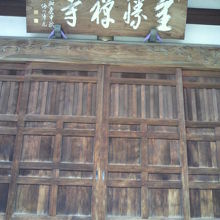全勝寺の正面の木製の扉とその上の額の近影です。