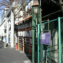 海幸橋の標識の向こうに、波除神社の鳥居と提灯が見えます。