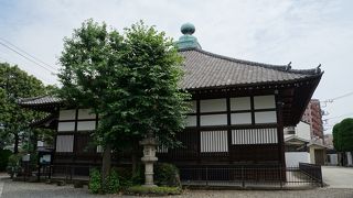 寄棟造りの屋根の上に大きな青い宝珠