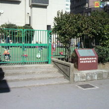 日本点字制定の地の碑の様子です。柵の向こうは、築地保育園です