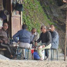 海辺で仲間とのんびりするおじいちゃんたち