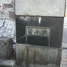 新金橋の親柱です。左の金網越しに首都高速道路が見えます。