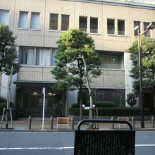 三つ橋跡の標識の背景は、中央区役所の施設がある京橋プラザです