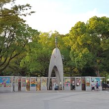 緑の中に、少女の像がある。像の前で折鶴講座をやっていた。