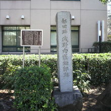 浅野内匠頭邸跡の石碑と標識です。背景は、聖路加国際大学です。