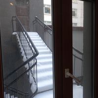 窓の外は隣の建物の入口だった