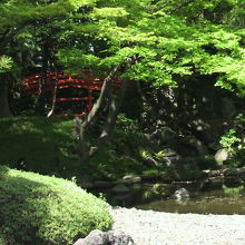 大堰川の川岸から、木間越しに見る通天橋です。緑の紅葉ですが。
