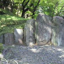 小石川後楽園の屏風岩とその左側に立てられている解説板です。