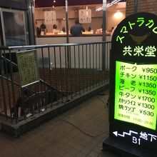 路上に緑の看板あり。店は地下1階