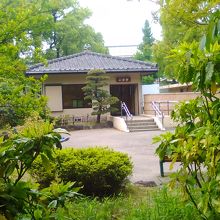 旧安田庭園の回遊路の木間越しに建物が見えます。心字亭です。