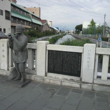 平等川を背景にした石和橋の上の権三郎の石碑と左側の銅像です。