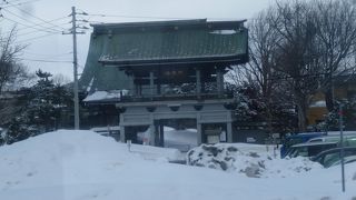 雪でも目立つ山門に本堂の青銅葺き屋根