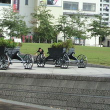 芝生のすぐ横には、緑の植物に飾られた馬車が置かれています。