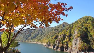青い湖面に赤や黄、緑の山肌が美しいコントラスト（10月半ば）
