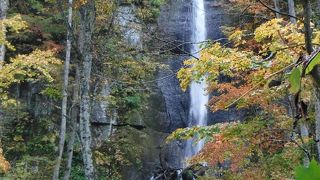 オレンジに染まる木々の間から見える滝