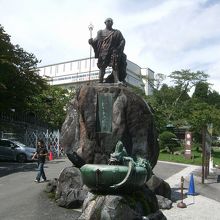 修復中の三仏堂の前の勝道上人像。