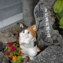 入口の左脇の植え込みに埋もれている小さい店名の看板