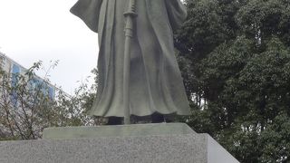 右手を前に突き出し和服姿の像