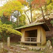 山道の先には美しい紅葉と小さな庵