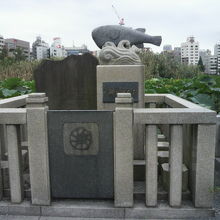 石柱の囲いに囲まれたふぐ供養碑です。ふぐの像がユーモラスです