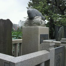 ふぐ供養碑の解説の石碑とともにふぐの像が見えます。ユーモラス