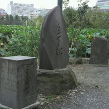 弁天堂の包丁塚と説明の石碑を東側の斜めから見ている写真です。