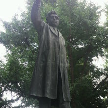 野口英世が試験管の試料をかざし、実験している様子の像です。