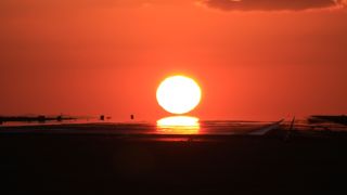 滑走路に夕日が沈む