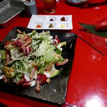 シーザーサラダ　向こうに魚串焼きの薬味