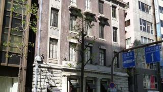 石貼りの一階ファサードと、２階から上の小豆色のレンガを使った外壁デザインが非常に美しいレトロビル。