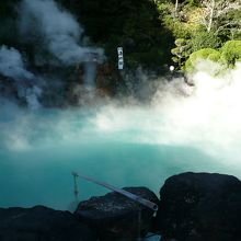 ブルー色の池から湯煙が昇っている。