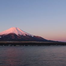 公園から見た朝焼けの富士山と満月