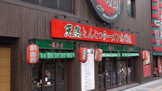 たくさんの赤い提灯とビルの側壁に大きな看板があるラーメン屋さんです
