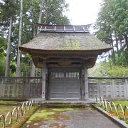 春日山城の裏門を移築したという萱葺きの門があります。