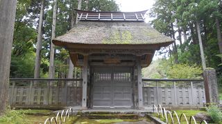 春日山城の裏門を移築したという萱葺きの門があります。