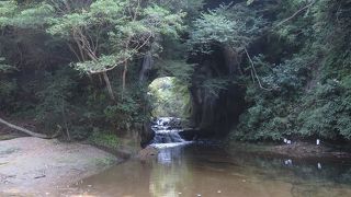 洞窟の向こうから水の流れとともに、光が差し込み、神秘的な雰囲気が漂っています。
