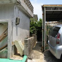 住宅の塀の隙間の細い通路の先に識名壕がある